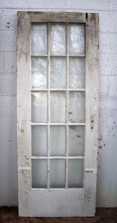 an old window is shown against a white brick wall