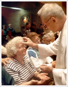 an older woman getting her hair combed by a man in a white robe and striped shirt