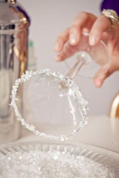 a person is holding a wine glass in their hand and pouring it into a bowl