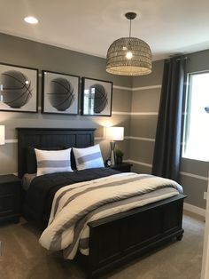 a bedroom with a large bed and two framed basketballs on the wall above it