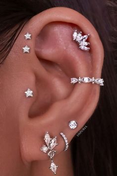 a woman wearing three different piercings on her ear