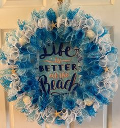 a blue and white wreath that says life is better at the beach