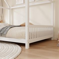 a white bed sitting on top of a hard wood floor next to a lamp and rug