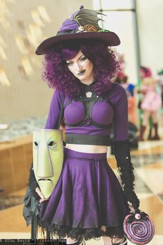 a woman dressed up as a witch with purple hair