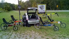 a car is parked next to two bicycles and a bicycle trailer with the back door open