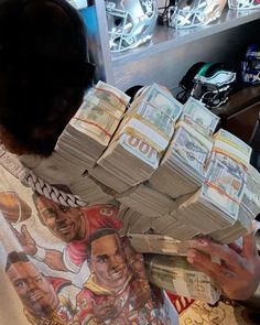 a man is holding stacks of money in his hands and looking at the cash he's got