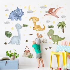 a child reaching up to the wall with dinosaurs and stars on it in front of them