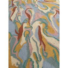 a multicolored rug with an abstract design on the bottom, and a white background