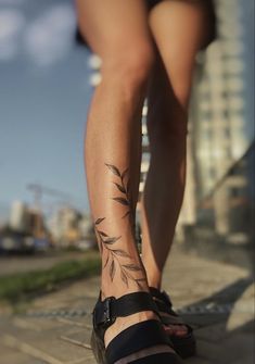 a woman's legs with tattoos on them and her foot in the middle of the photo