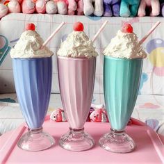 three ice cream sundaes sitting on top of a pink tray