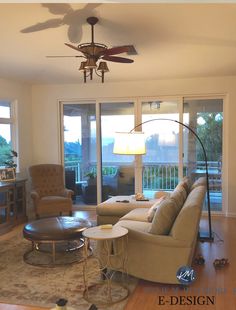 a living room filled with furniture and a ceiling fan in front of a sliding glass door