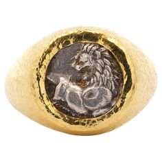 Ancient Greek Lion Hemidrachm 400 BC In 20K Gold with Hammered Finish Men's Ring One of the earliest coins from a Greek city-state, the diminutive silver Cherronesos Hemidrachm stands as a remarkable artifact from Ancient Greece’s Archaic Period. This coin showcases a dynamic depiction of a running lion glancing backward on one side and a distinctive quadripartite incuse square—a pattern of four squares—on the reverse, epitomizing the artistry of early numismatics. The coin's thick, rounded form Ancient Lion, Greek City, Mens Ring, City State, Men's Ring, Ancient Greece, Ancient Greek, Cocktail Rings, Solitaire Ring