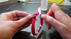 two hands holding a lighter on top of a table