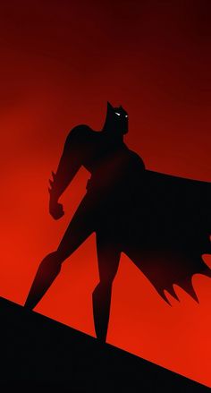 the shadow of a batman standing on top of a hill with his arm outstretched in front of him