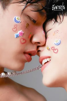 two people with their faces covered in stickers and nose piercings are kissing each other