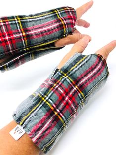 two hands are wearing plaid gloves with one hand in the other's palm, both holding