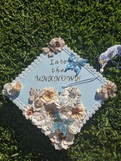 a blue and white sign with flowers on it that says into the unknown in gold lettering