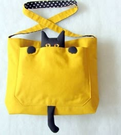 a yellow purse with a black cat on it