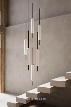 a modern chandelier hanging from the ceiling in a room with concrete walls and stairs