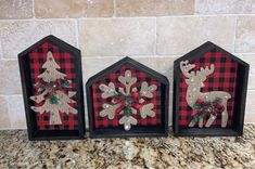 three christmas decorations are sitting on a counter