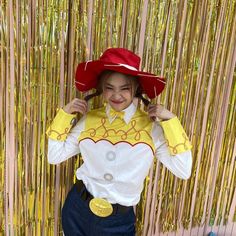 a woman wearing a yellow and white shirt with a red hat on top of her head