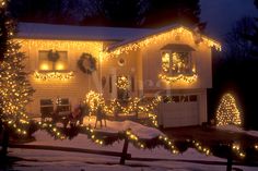 a house covered in christmas lights and wreaths