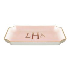 a pink and gold tray with the letter h on it's side, in front of a white background