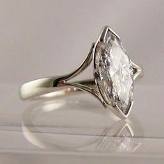 a white diamond ring sitting on top of a table