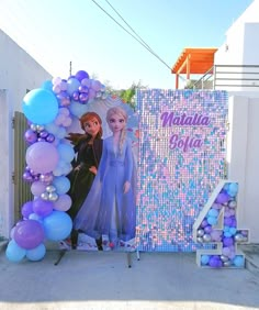 there is a large balloon arch with two frozen princesses on it