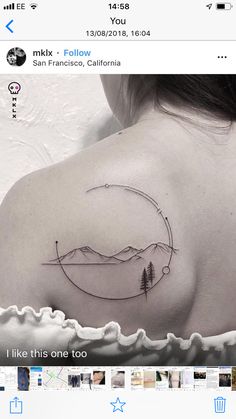 the back of a woman's shoulder with mountains and trees on it