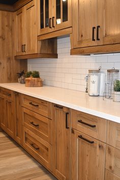 a kitchen with wooden cabinets and white counter tops