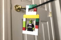 a door hanger made out of legos is hanging on the front door,