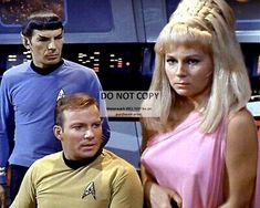 two men and a woman standing next to each other in front of a star trek scene