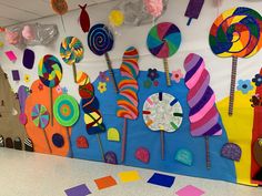 a classroom wall decorated with lollipops, candy and paper plates on it