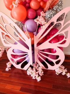 there is a large paper butterfly surrounded by balloons