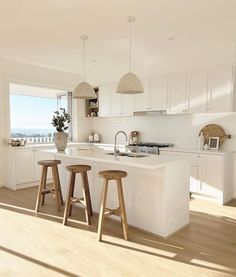 a kitchen with two stools next to an island