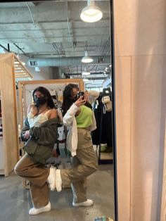 two women are taking pictures in the mirror