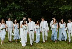 a group of people standing next to each other on top of a lush green field