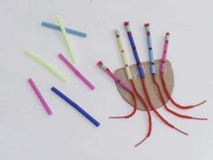 several different colored toothbrushes are arranged on a piece of paper with red string