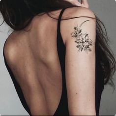 a woman with a flower tattoo on her left arm and right arm behind her back