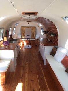 the interior of an airplane with wood flooring and white couches on either side