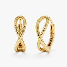 two pairs of gold toned earrings with twisted design on each ear, one in the shape of an x