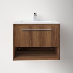 a bathroom sink mounted to the side of a white wall next to a wooden cabinet