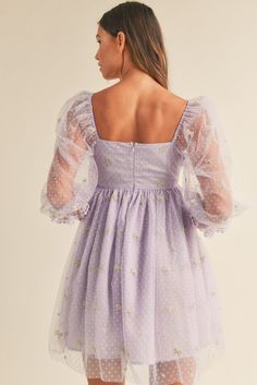 This is the dreamiest lavender haze dress all wrapped up in tulle and darling ribbon print details! This lovely dress is crafted from a Swiss dot mesh material with detailed ribbon coquette bow embroidery all throughout and finished with a mini hem length! Perfect for any occasion! 3/4 sleeve Babydoll cut Embroidered ribbon print Swiss dot mesh/tulle Mini dress Square neckline Back zipper Fully lined 50% poly 50% viscose True to size Size Guide: SMALL: WOMEN'S 2/4 MEDIUM: WOMEN'S 4/6 LARGE: WOME Dreamy Fitted Spring Dress, Whimsical Evening Dresses For Spring, Lavender Summer Prom Dress, Lavender Tulle Dress With Ruffles, Feminine Lavender Dress With Sweetheart Neckline, Lavender Prom Dress For Summer, Lavender Mini Dress For Prom And Spring, Lavender Mini Dress For Spring Prom, Summer Tulle Dress Balletcore Style