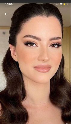 a woman with long hair and brown eyes is looking at the camera while wearing makeup