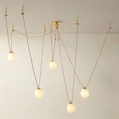 five light fixtures hanging from the ceiling in a room with white walls and flooring