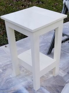 a white table sitting on top of a cement ground