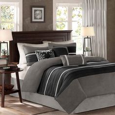 a bed with grey and black comforters in a bedroom