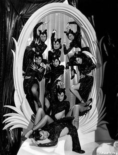 a group of women posing in front of a mirror with their legs spread out and hands on the hips