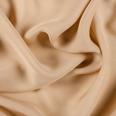 a close up view of a beige fabric with very smooth lines and folds on it